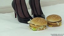 Une femme grimpe sur un hamburger avec des bas