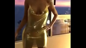 Chica joven sexy está mostrando su sexy vestido dorado