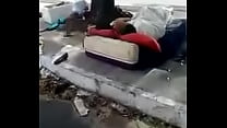 Hombre sin hogar jugando en medio de la calle