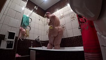 Nos bastidores, uma câmera escondida espia uma modelo pornô gorda com uma bunda grande no banheiro.