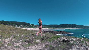 Russin Sasha Bikeyeva - Spanien Galizien Strand Doninos. Nacktes FKK-Mädchen des perfekten Körpers, das an der Atlantikküste neckt und tanzt