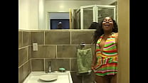 Chica de ébano con medias de rejilla blancas meando en el baño y filmando