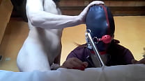 Tied to a machine, masked and hooded, she has to suck a big cock