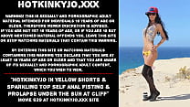 Hotkinkyjo em shorts amarelos e top brilhante auto-fisting anal e prolapso sob o sol no penhasco